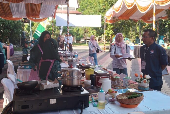 Salah seorang juri mengecek hasil olahan ikan peserta lomba masak berbahan dasar ikan pada puncak HKG PKK Kota Mataram, Kamis 25 Juli 2024. (ekbisntb.com/ift)