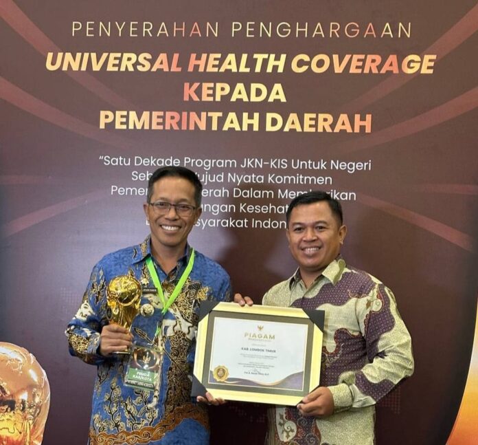 Bupati Lotim H. M. Juaini Taofik menerima penghargaan UHC Award. (ekbisntb.com/ist)
