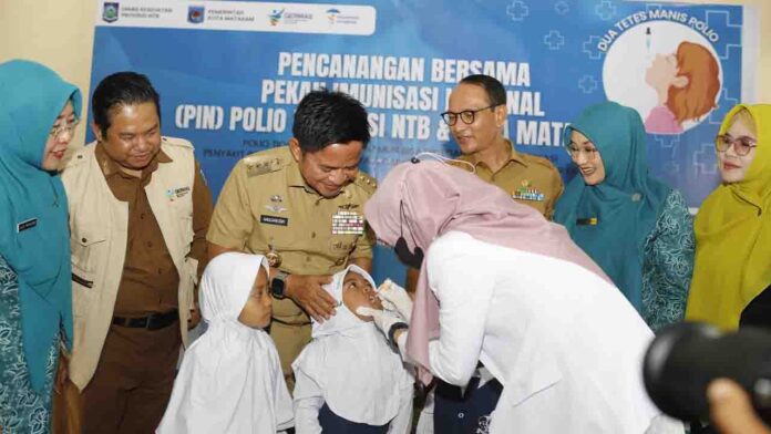 Pj Gubernur NTB Hassanudin saat menyaksikan anak-anak disuntik vaksin polio didampingi Wali Kota Mataram, Selasa 23 Juli 2024.(ekbisntb.com/ist)