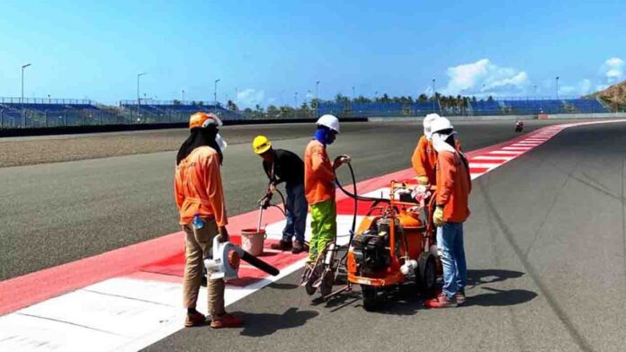 Pekerja tengah melakukan pengecatan area run off lintasan Sirkuit Mandalika sebagai bagian dari persiapan menyambung ajang MotoGP Mandalika 2024.(ekbisntb.com/ist)