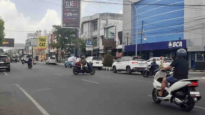 Seorang juru parkir di Jalan Pejanggik, Cakranegara mengatur kendaraan pada, Selasa 29 Oktober 2024. Dinas Perhubungan Kota Mataram melakukan uji petik di 14 titik parkir untuk mengetahui potensi salah satu sumber pendapatan asli daerah. Capaian retribusi parkir mencapai Rp7,6 miliar. (ekbisntb.com/cem)