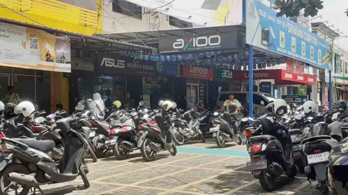 Seorang jukir di salah satu pusat pertokoan di Jalan Sriwijaya Kota Mataram menjaga kendaraan terparkir pada, Rabu 22 Januari 2025. Diduga masih ditemukan kebocoran parkir di Kota Mataram akibat maraknya jukir liar. (ekbisntb.com/cem)