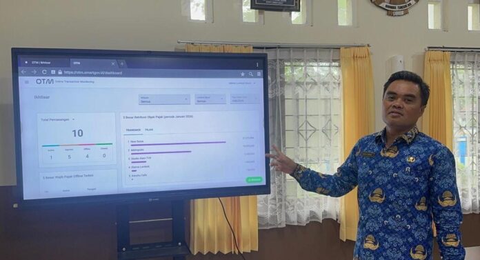 Kepala Bapenda Lobar Lalu Agha Farabi menunjukkan monitor pemantauan realisasi pajak secara real time. (suarantb.com/her) Target PAD Naik, Bapenda Lobar Maksimalkan Digitalisasi