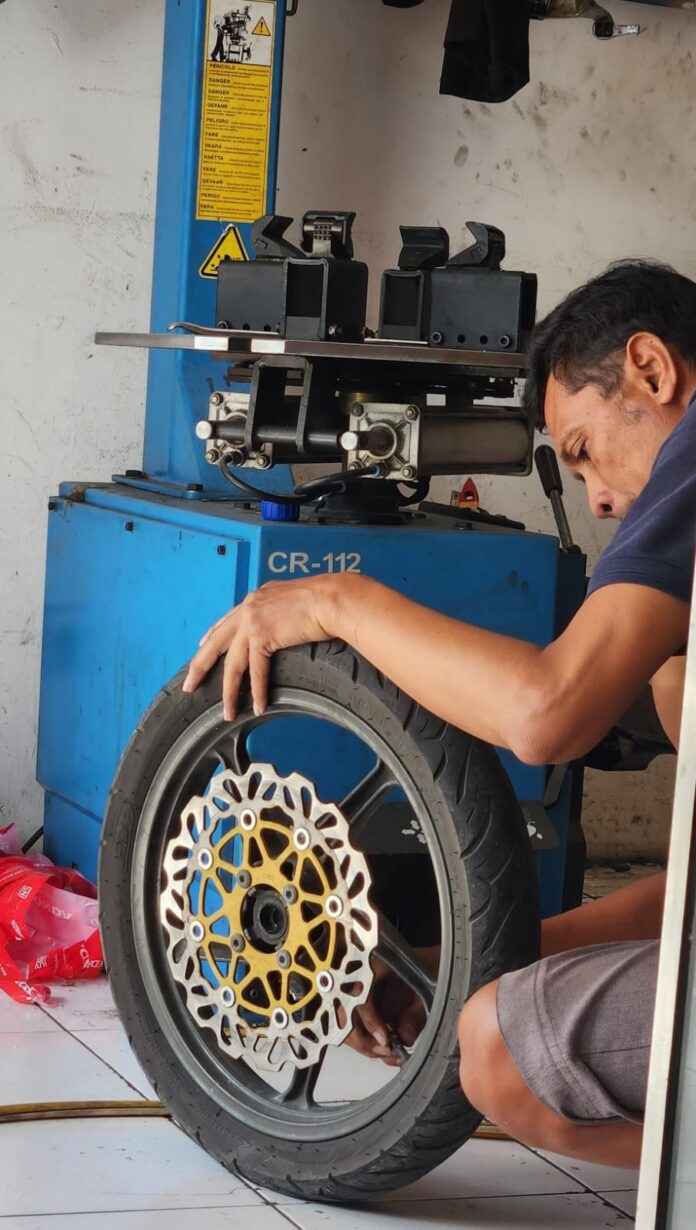 Seorang montir sedang memperbaiki roda sepeda motor. Belakangan ini, harga spare part kendaraan mengalami kenaikan imbas perang di Timur Tengah. (Suara NTB/bul) Harga ‘’Spare Part’’ Motor Naik, Oli dan Ban Paling Tinggi