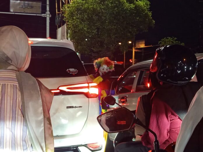 BADUT - Seorang badut jalanan menghibur para pengendara di Simpang Empat Tahah Aji, Jalan Sriwijaya yang dipotret beberapa waktu lalu. Pengamen dan Gepeng di Mataram akan ditata, Dinsos utamakan rehabilitasi dan pemberdayaan. (Suara NTB/pan)