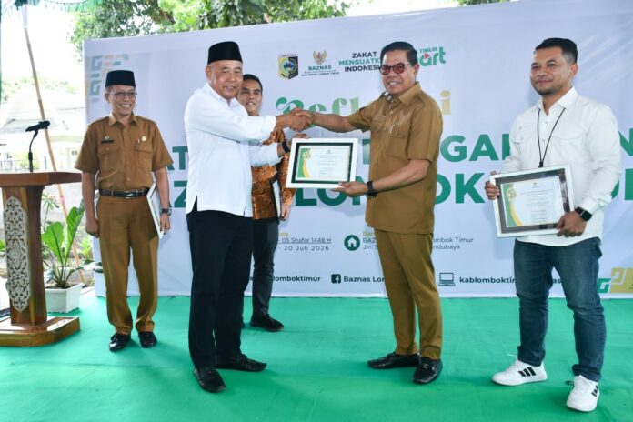 Bupati Lotim H. Haerul Warisin menerima penghargaan dari Ketua Baznas Lotim, Muhammad Kamli. (Suara NTB/rus) Bupati Lombok Timur Tak Puas dengan Capaian Zakat Rp24 Miliar