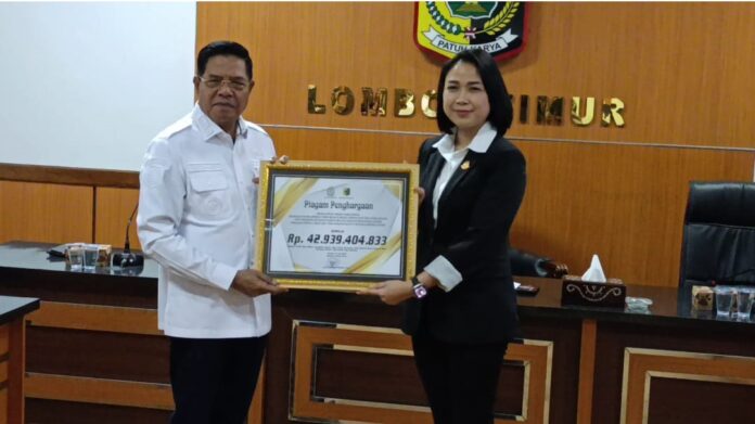 BERI PENGHARGAAN - Bupati Lotim H. Haerul Warisin (kiri) memberikan penghargaan kepada Kejaksaan Negeri Lotim atas keberhasilan memberikan pemulihan keuangan daerah, Rabu (29/7/2026).(Suara NTB/rus) Kejari Lotim Bantu Pemulihan Keuangan Daerah Rp53,5 Miliar