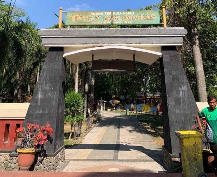 RTH SELAGALAS - Seorang pengunjung berdiri di depan gapura RTH Selagalas di Jalan Ahmad Yani, Kelurahan Selagalas, Kecamatan Sandubaya pada Selasa (8/9). (EKBIS NTB/pan) DLH Mataram Siapkan Rp5 Miliar untuk Revitalisasi RTH Selagalas