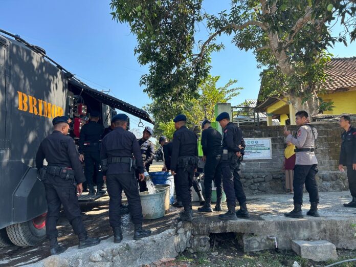 DISTRIBUSI AIR - Anggota Satuan Brimob Dompu saat mendistribusikan air bersih kepada warga pada, Selasa (9/9). (Suara NTB/ula) Rutin Distribusikan Air Bersih