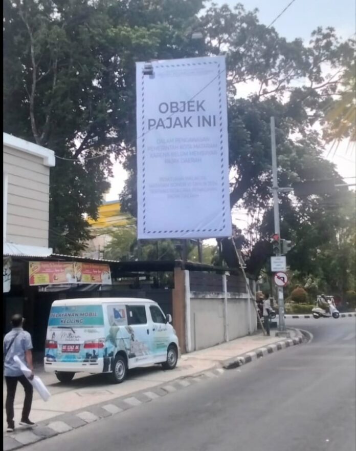 (EKBIS NTB/ist) DISEGEL – Badan Keuangan Daerah Kota Mataram menyegel papan reklame yang menunggak pajak di Jalan Airlangga pada, Kamis (24/9). Masyarakat diimbau meningkatkan ketaatan dan kepatuhan membayar pajak. Nunggak PajakDelapan Papan Reklame Disegel